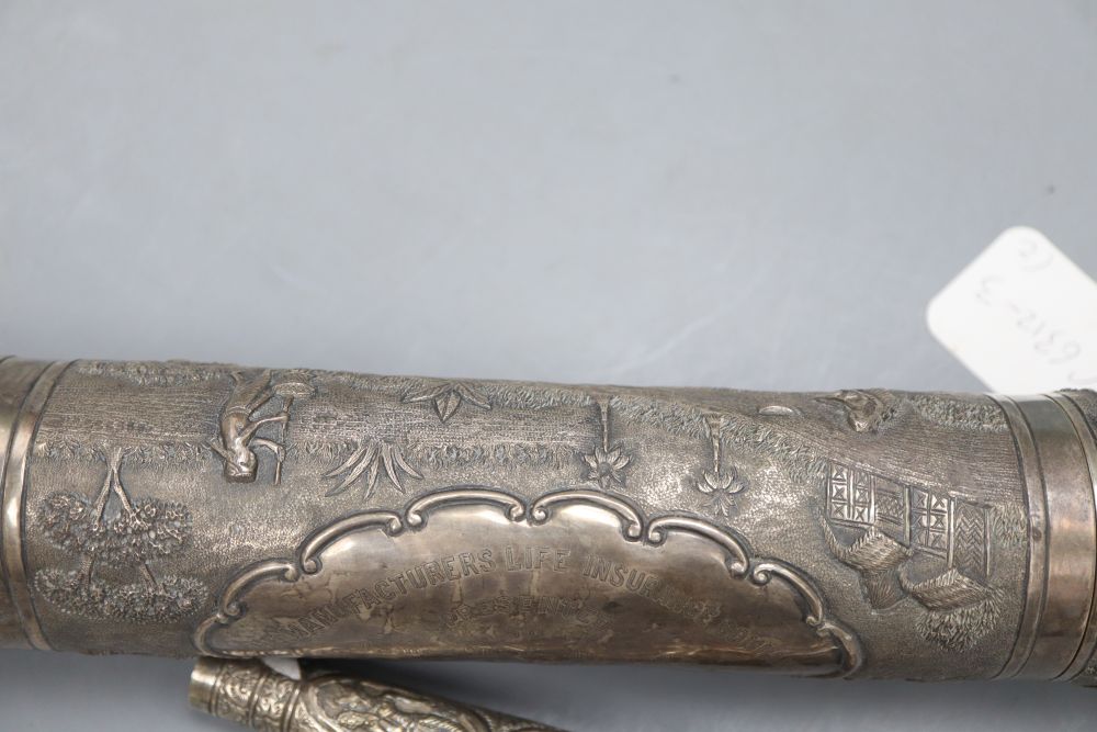 A 20th century Indian white metal scroll holder, 40.4cm and a white metal parasol handle, 16cm